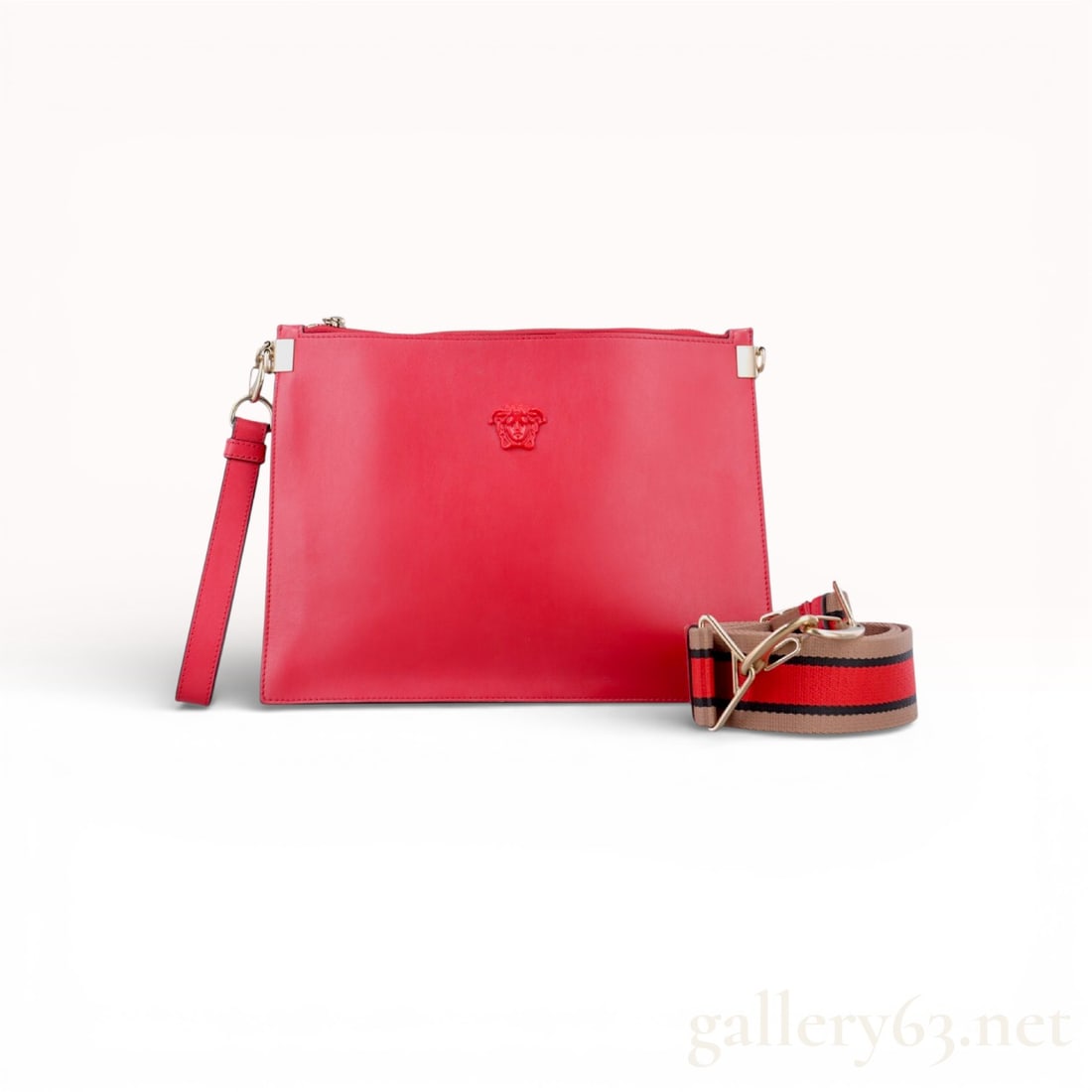 Versace La Medusa Palazzo Red Leather Clutch Bag with Strap: Authentic Versace clutch bag in red leather, from the La Medusa Palazzo line. The bag features a slim rectangular silhouette with a top zip closure and an embossed Medusa head motif centered on the