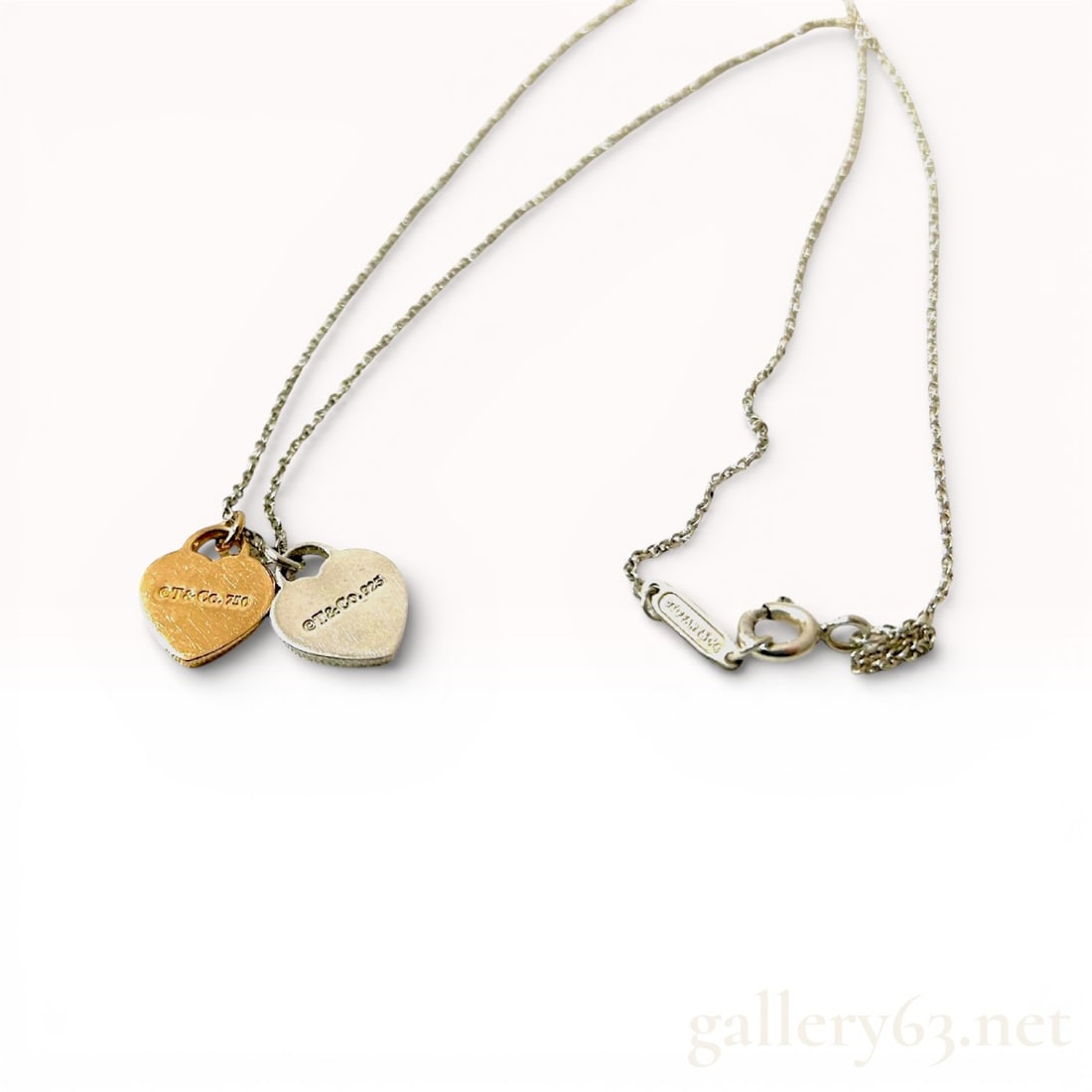 Tiffany & Co. Return to Tiffany Double Heart Sterling Silver and 18k Rose Gold Necklace with Pouch: Tiffany & Co. Return to Tiffany necklace featuring a double heart charm design suspended from a fine sterling silver chain. One heart rendered in sterling silver engraved with the Return to
