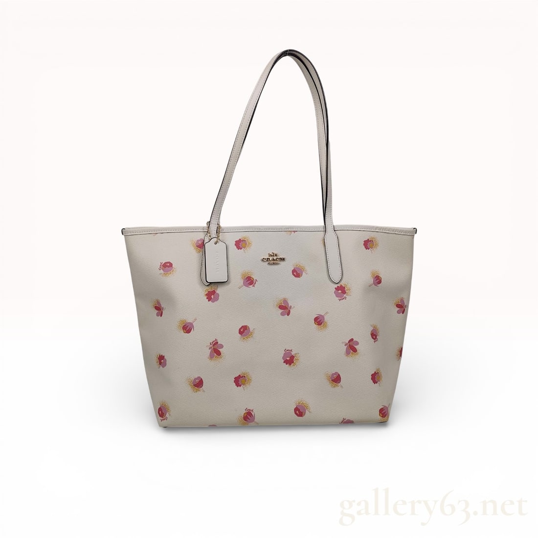 Coach City Tote with Pop Floral Print: uthentic Coach City Tote in ivory pebbled leather, featuring a scattered pop floral print in pink and yellow tones. The streamlined rectangular silhouette includes dual long shoulder straps, gold