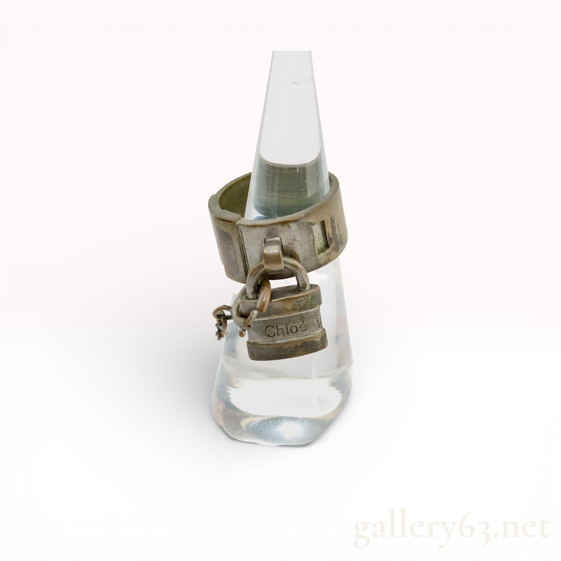 Chloé Lock Band Ring with Padlock Charm, Size 6.5: Authentic Chloé Lock band ring in silver tone metal, featuring a wide band with engraved detailing and attached padlock charm. The dangling lock is engraved with the Chloé name and suspended from a