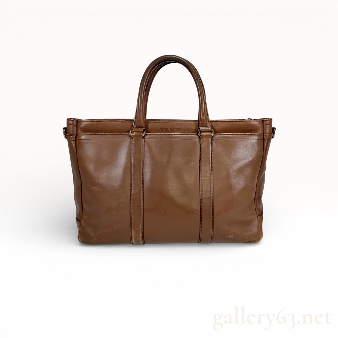 Coach Men's Briefcase Lexington Leather Metro Bag, Model F70916: Authentic Coach Lexington Metro briefcase F70916 in brown smooth leather, featuring a structured rectangular silhouette with reinforced vertical leather trim. The design includes dual rolled top handl