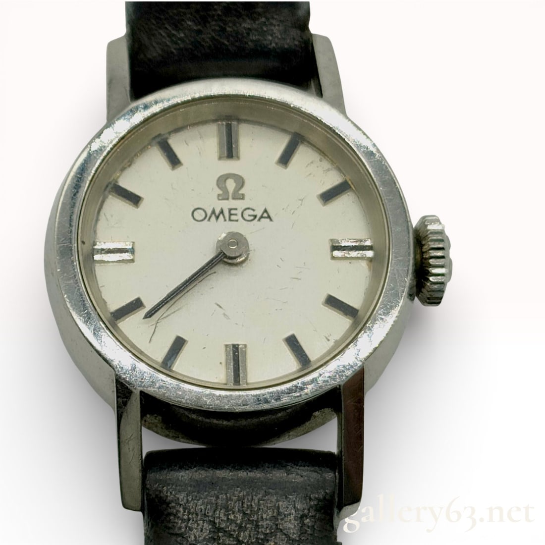 Omega Vintage Ladies Wristwatch: Authentic Omega ladies wristwatch featuring a petite round silver-tone case and a light dial with applied baton hour markers. The dial is signed Omega with the Omega symbol beneath 12 o’clock and fi