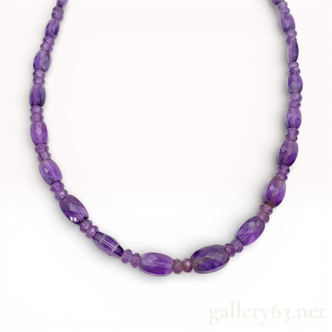 18k Yellow Gold Amethyst Beaded Necklace 20.7g: 18k yellow gold necklace featuring graduated amethyst beads in oval and round forms. Amethysts display medium to deep purple tone with faceted and polished finishes. Necklace secures with an 18k yello