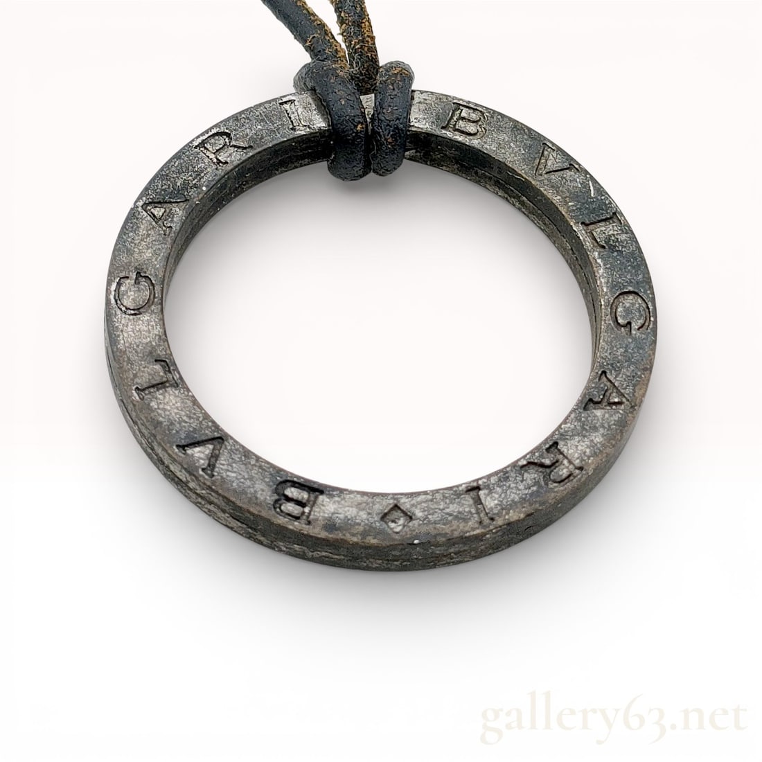 Bvlgari Bvlgari 925 Sterling Silver Circular Pendant Necklace on Cord: Sterling silver Bvlgari pendant necklace featuring the iconic circular Bvlgari Bvlgari logo ring engraved around the outer edge. Pendant suspended from a black cord necklace with adjustable chain exte