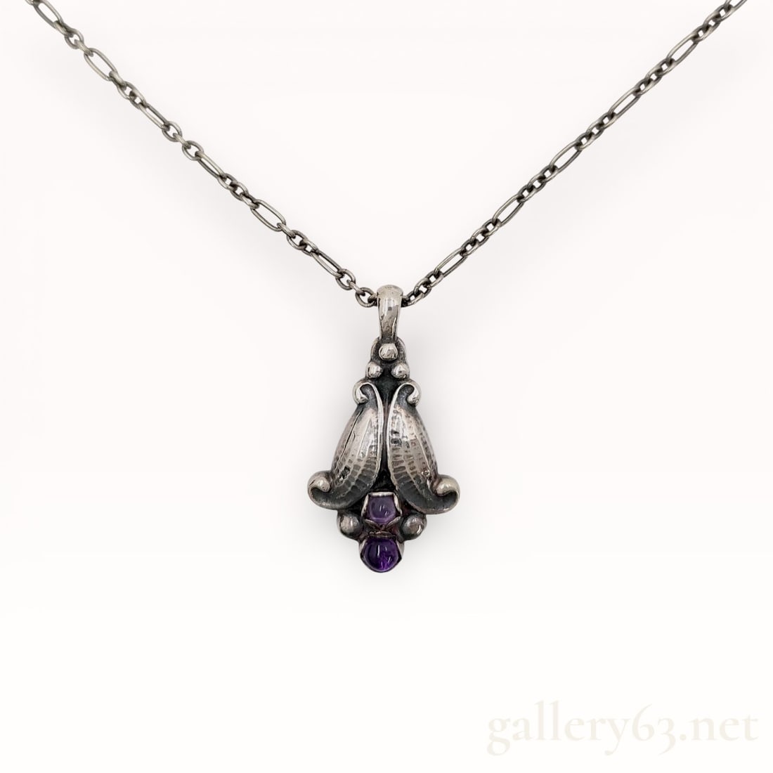 Georg Jensen .925 Silver Purple Stone 1998 Necklace With Box: Authentic Georg Jensen Necklace. Silver chain and a sculptural pendant of symmetrical organic form, featuring textured leaf-like elements and applied bead details. Design including a centrally set
