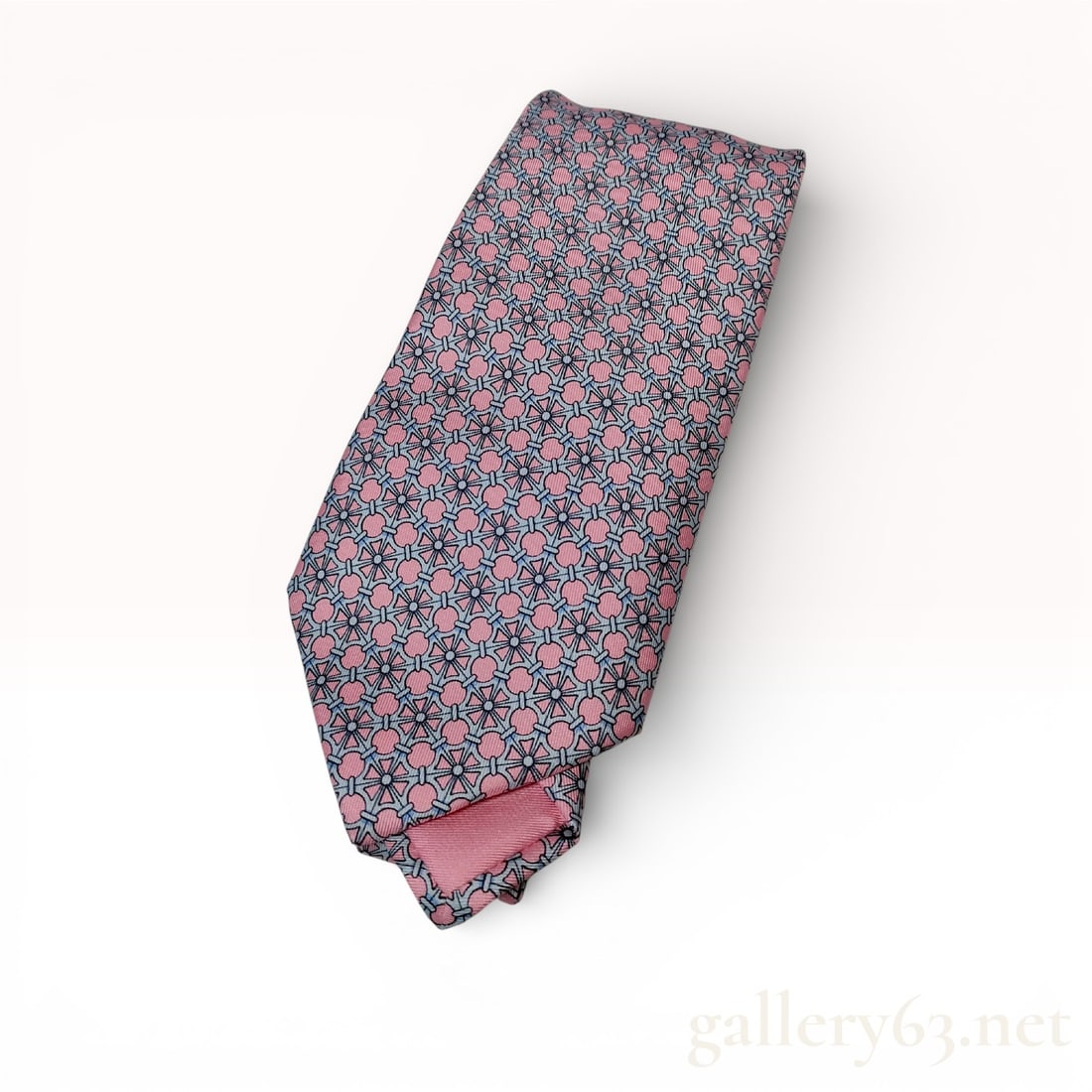 Hermes Paris Geometric Silk Necktie, Pink: This authentic Hermes Paris men's necktie is crafted in France from 100% silk (soie). The piece features an intricate repeating geometric pattern of interlocking circular and linear motifs. The color