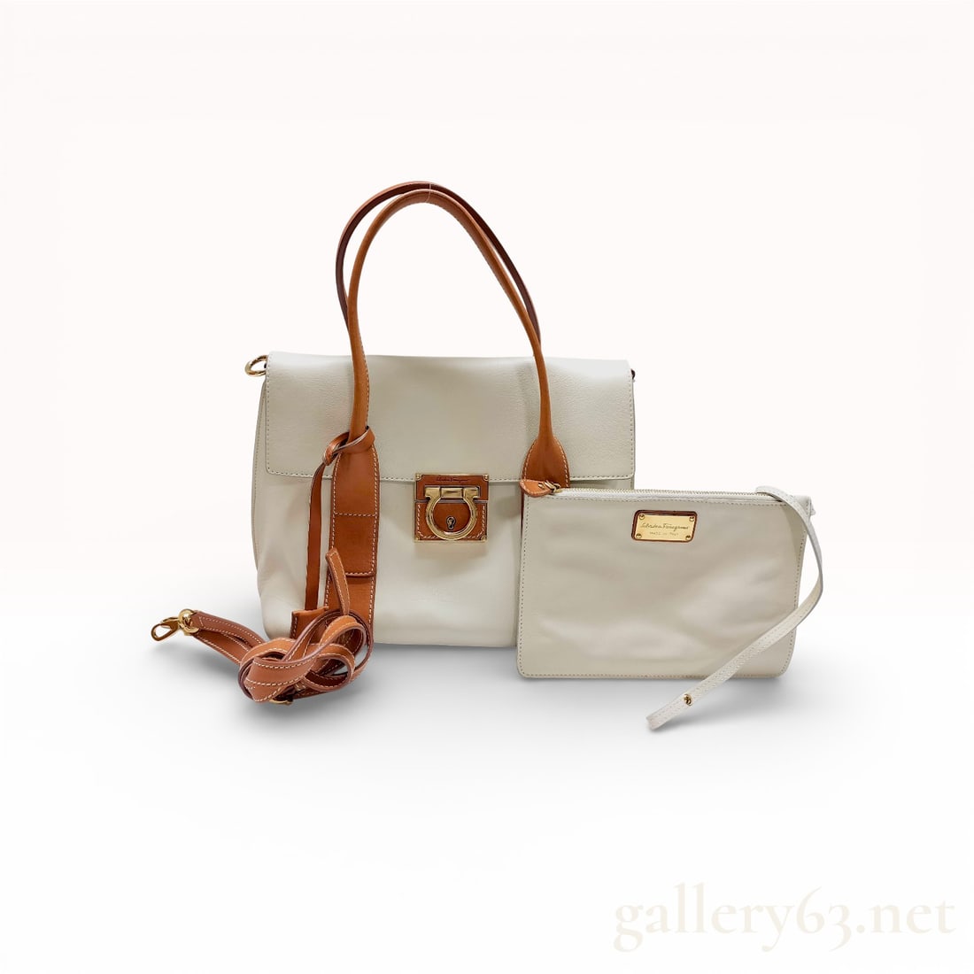 Salvatore Ferragamo Gancini Two-Tone Leather Flap Tote Bag: This Salvatore Ferragamo tote is crafted from premium grained and smooth calfskin leather in a sophisticated cream and tan colorway. The design features a front flap secured by an oversized gold-tone