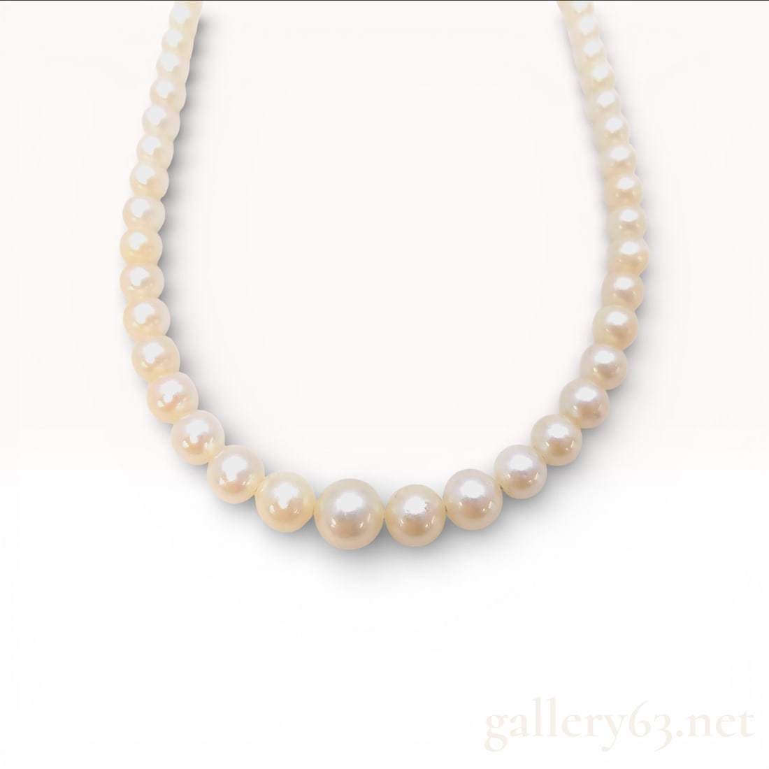 Silver Graduated Akoya Pearl Necklace with Filigree Clasp: This necklace features a single strand of cultured Akoya pearls. The pearls are graduated in size, ranging from approximately 3.5mm at the ends to 7.0mm at the center. The pearls exhibit a creamy whit