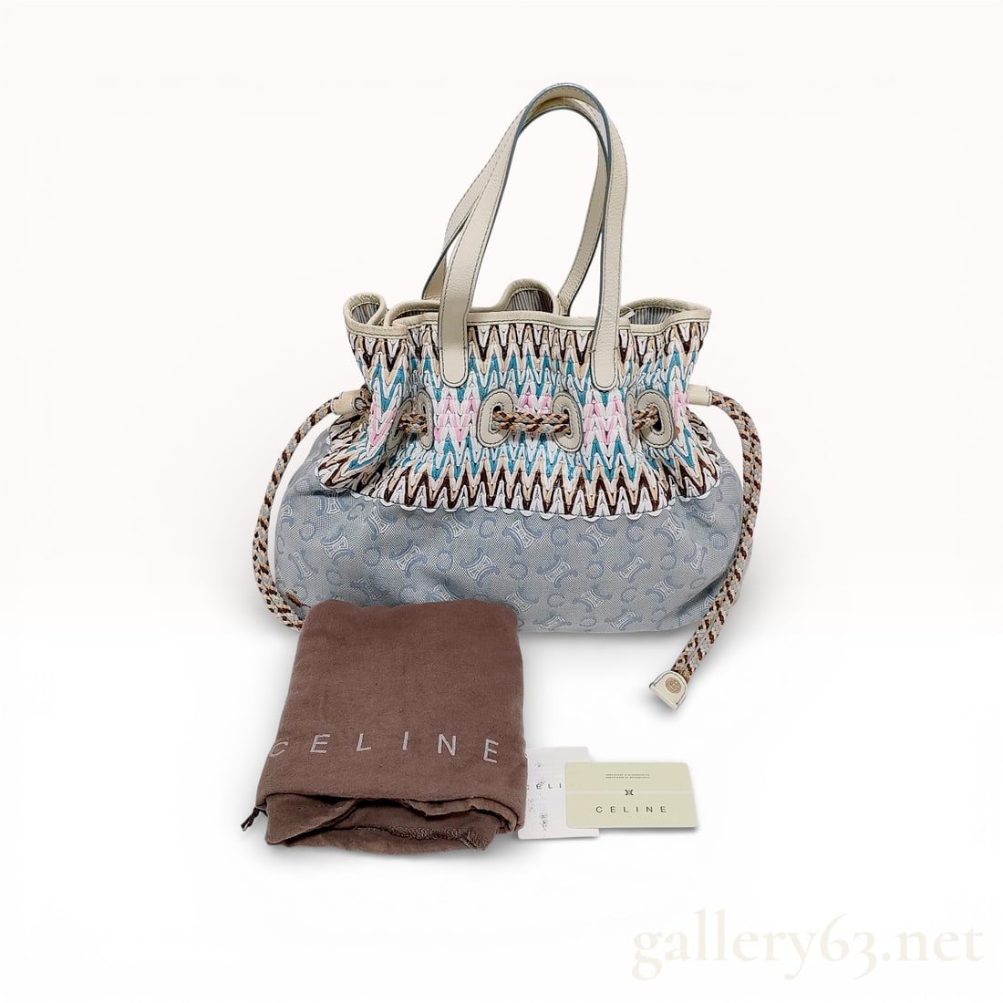Celine C Macadam Straw Drawstring Tote Bag Canvas and Leather Multicolor: This Celine drawstring cinch tote bag features a bohemian-inspired aesthetic, combining a light blue C Macadam monogram canvas base with a multicolor woven straw upper panel in a chevron zigzag patter