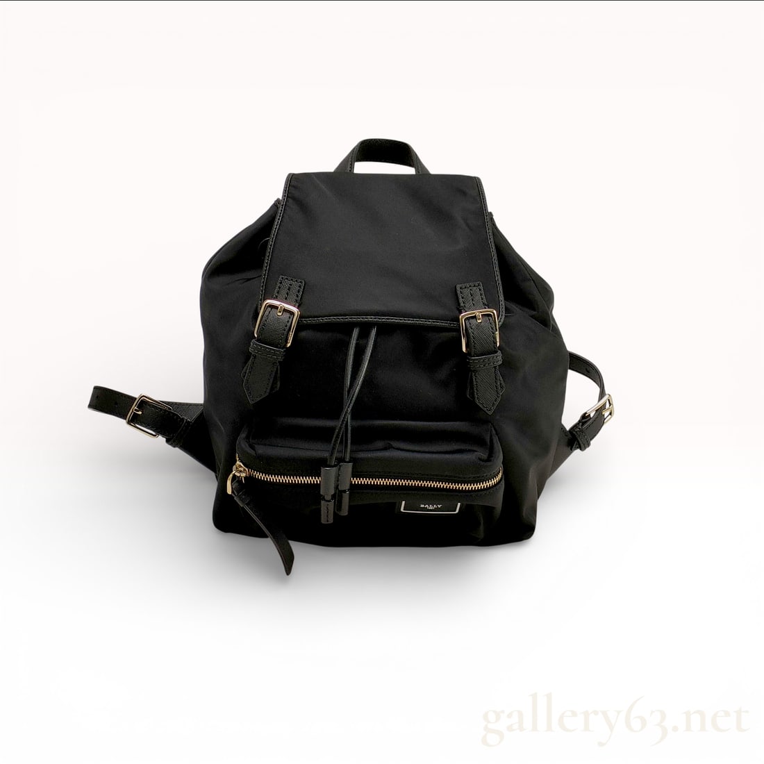 Bally Mini Nylon Backpack Saffiano Leather Black: This Bally mini backpack is constructed of durable black nylon with black Saffiano leather trim and straps. It features gold-tone hardware throughout. The exterior includes a front zippered pocket wit