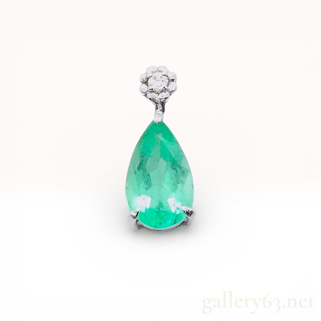 18K White Gold Pendant with Pear-Cut Emerald and Diamond Floral Cluster: This 18k white gold pendant features a single pear-cut natural emerald and a diamond floral cluster. The primary emerald weighs approximately 1.34 carats and displays a medium-light green color with v