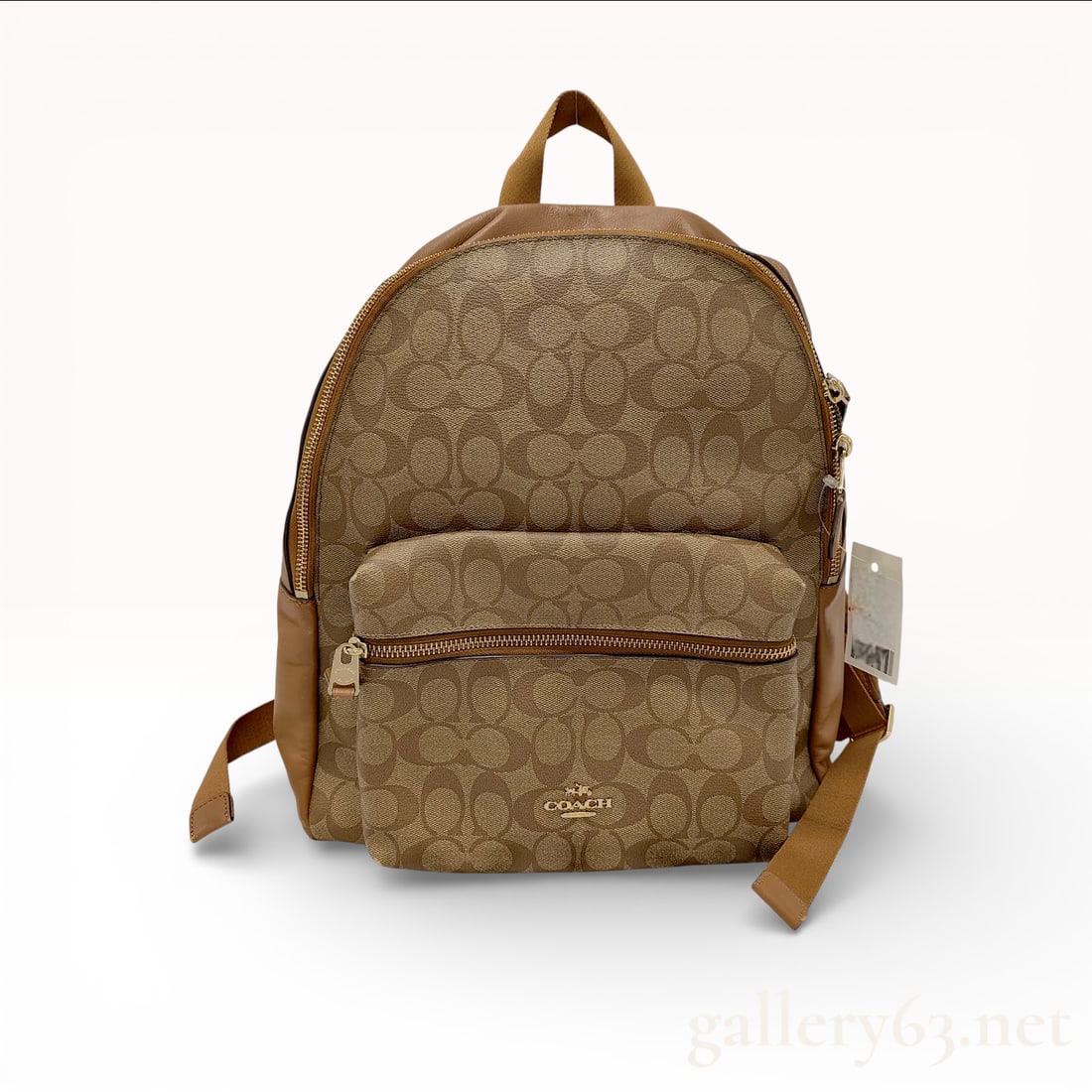 Coach Charlie Backpack in Signature Canvas, Khaki and Saddle: This Coach Charlie backpack is crafted from the brand's signature CC coated canvas in khaki, complemented by saddle brown smooth leather trim and a durable nylon back panel. The exterior features a la