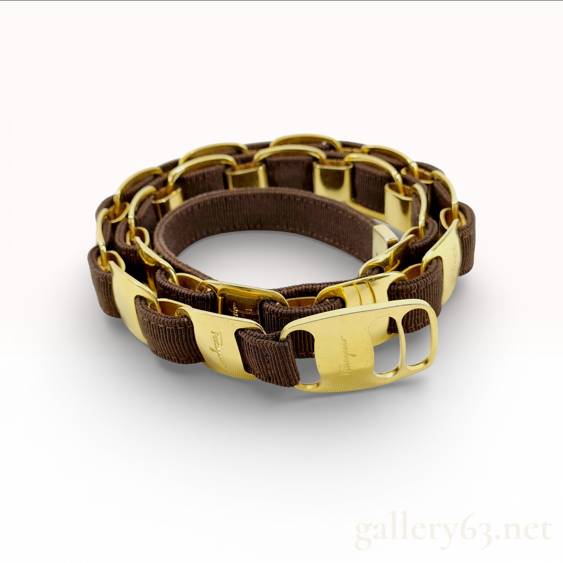 Salvatore Ferragamo Brown Grosgrain and Gold-Tone Chain Link Belt: This elegant Salvatore Ferragamo chain link belt is a sophisticated Italian-made accessory. It features a rich brown grosgrain ribbon expertly woven through polished gold-tone metal links. Several of