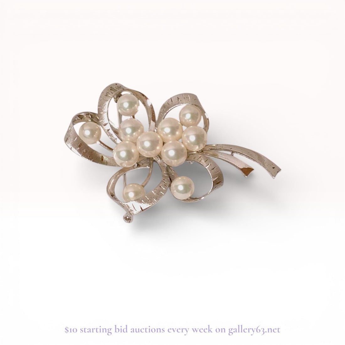 Sterling Silver Akoya Cultured Pearl Ribbon Brooch by Mikimoto: This vintage brooch by Mikimoto features a stylized floral and abstract ribbon spray motif crafted in sterling silver. The design is set with eleven round Akoya cultured saltwater pearls displaying a