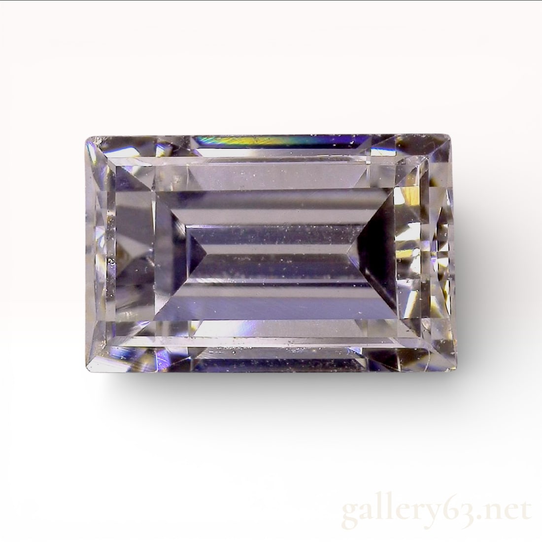 Natural Diamond, Rectangular Step Cut, 5.53 x 3.52 mm: This loose natural diamond features a rectangular step cut, commonly known as an emerald cut, characterized by parallel facets and slightly cropped corners. The stone is graded as E color and VS-2