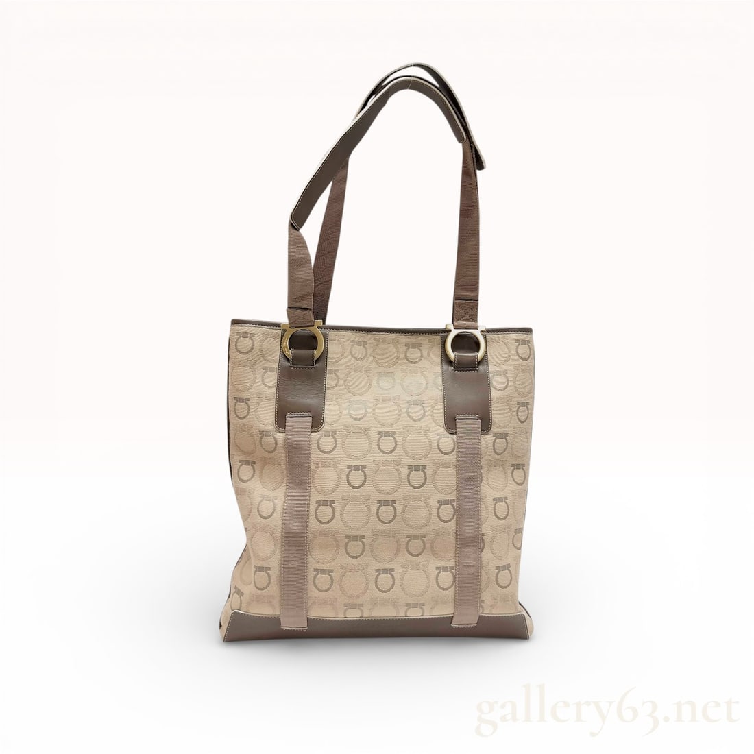 Salvatore Ferragamo Gancini Monogram Canvas Tote Bag in Beige and Brown: This Salvatore Ferragamo tote bag is crafted from beige canvas featuring the signature Gancini monogram pattern. The structured design includes smooth brown leather trim, a reinforced leather base, an
