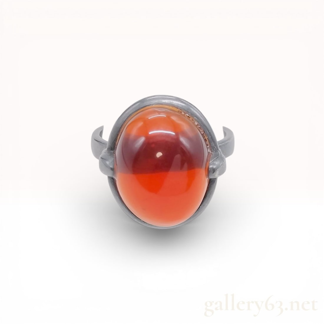 Bottega Veneta Sterling Silver and Carnelian Cabochon Cocktail Ring: A designer cocktail ring by Bottega Veneta, crafted in Italy from sterling silver with a dark oxidized patina. The ring features a large, oval-shaped red carnelian cabochon, bezel set within a substan