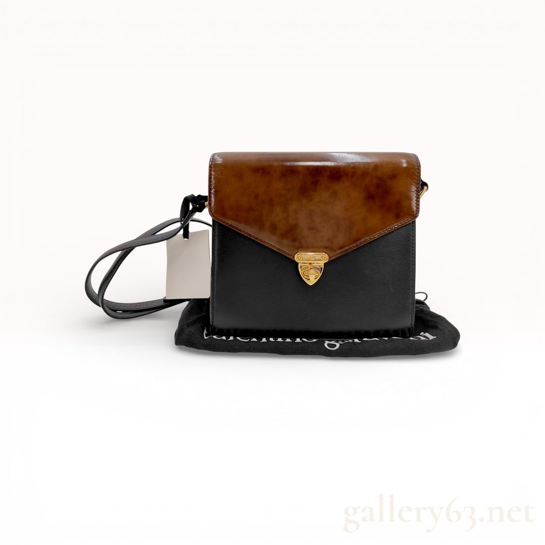 Valentino Vintage Two-Tone Leather Shoulder Bag Black and Brown: This vintage Valentino Garavani shoulder bag features a structured rectangular silhouette crafted from fine-grain black leather with a contrasting glossy mahogany brown mottled leather flap. The front