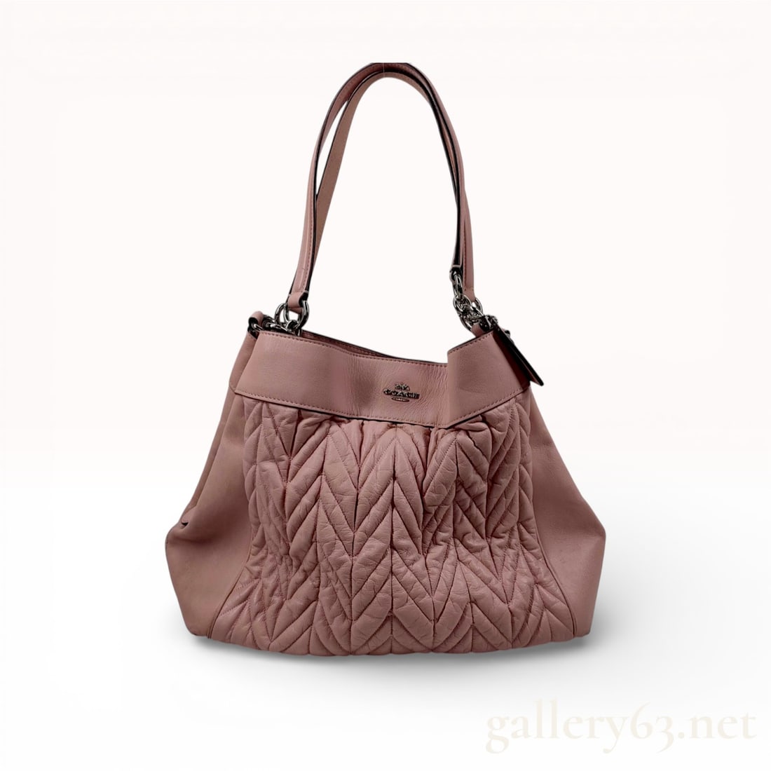 Coach Lexy Shoulder Bag in Chevron Quilted Petal Pink Leather: This Coach Lexy shoulder bag is crafted from chevron-quilted nappa leather in a Petal Pink hue with smooth leather trim. The exterior features polished silver-tone hardware, including a raised metal b