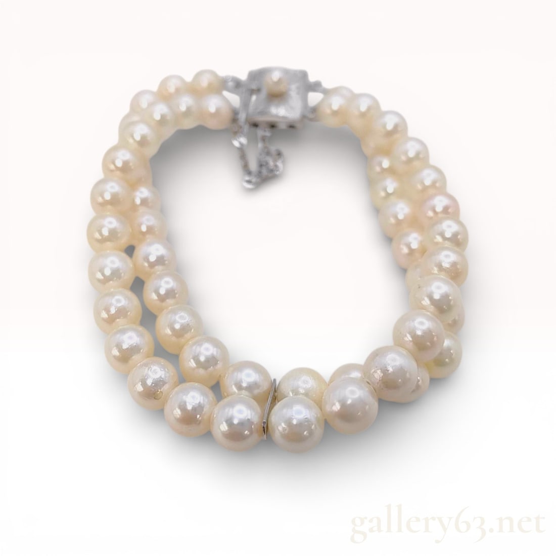 Silver Double-Strand Cultured Pearl Bracelet with Engraved Box Clasp: This double-strand bracelet features two matched rows of round white to cream cultured pearls, each measuring approximately 6.5 to 7 mm in diameter. The pearls exhibit high luster and clean surfaces,
