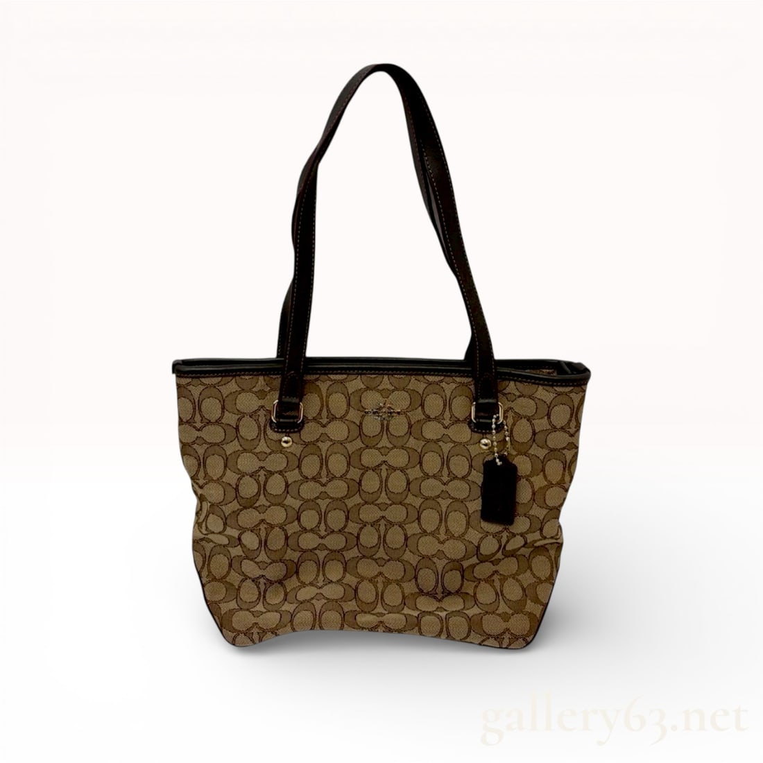 Coach Outline Signature Zip Top Tote, Canvas and Leather, Khaki and Mahogany: This Coach Outline Signature Zip Top Tote is crafted from durable signature jacquard canvas in a khaki and mahogany color scheme. The exterior features dark brown leather trim, reinforced base corners