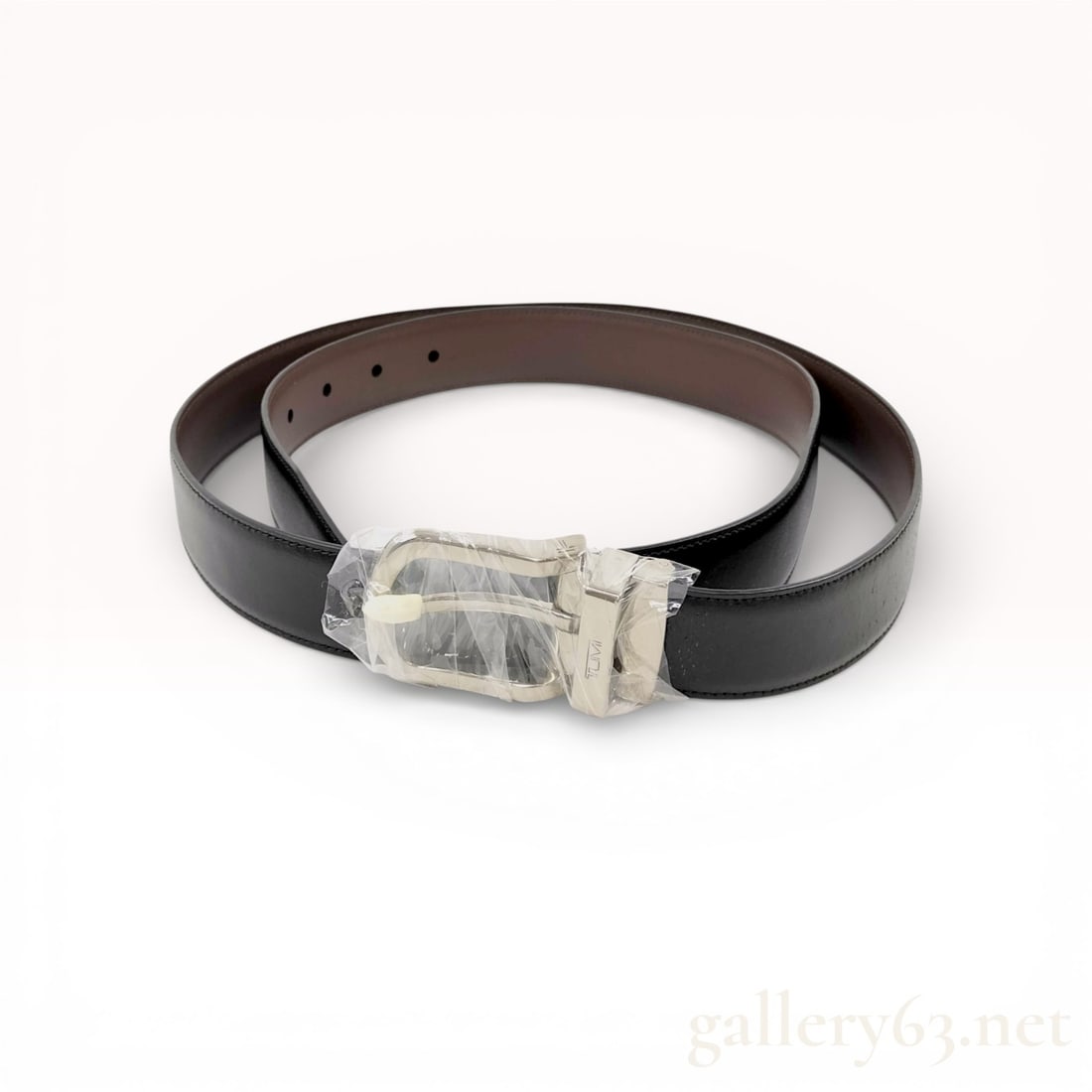 Tumi Men's Reversible Leather Belt with Box: A Tumi men's reversible belt featuring a smooth leather strap and polished silver-tone metal hardware. The design is reversible, with solid black leather on one side and solid brown leather on the rev