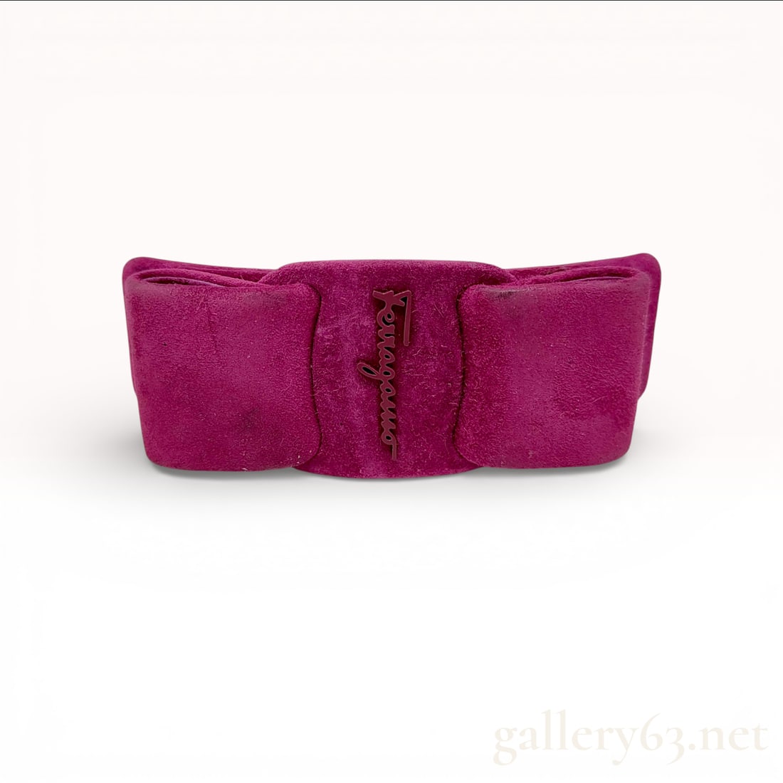 Salvatore Ferragamo Fuchsia Suede Vara Bow Hair Barrette: This classic hair accessory from the Italian luxury house Salvatore Ferragamo features the iconic Vara bow motif. The barrette is constructed from vibrant fuchsia suede and is centered with a matching