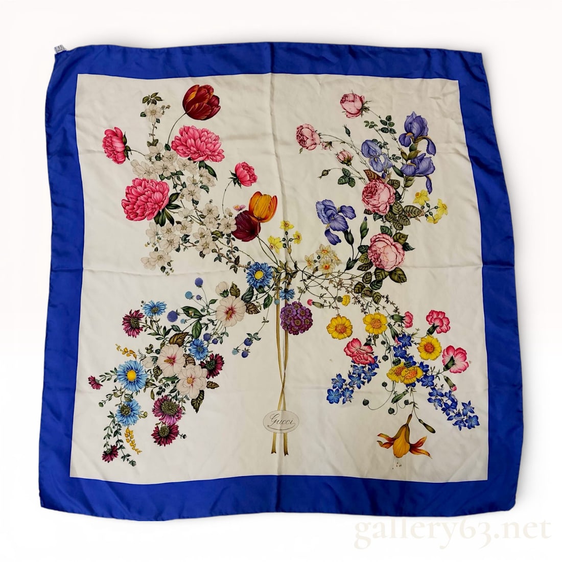 Gucci Flora Print Silk Scarf with Royal Blue Border: This vintage Gucci square scarf is made of 100 percent silk and features the iconic Flora botanical print. The design, includes a vibrant arrangement of flowers such as roses, tulips, irises, and popp