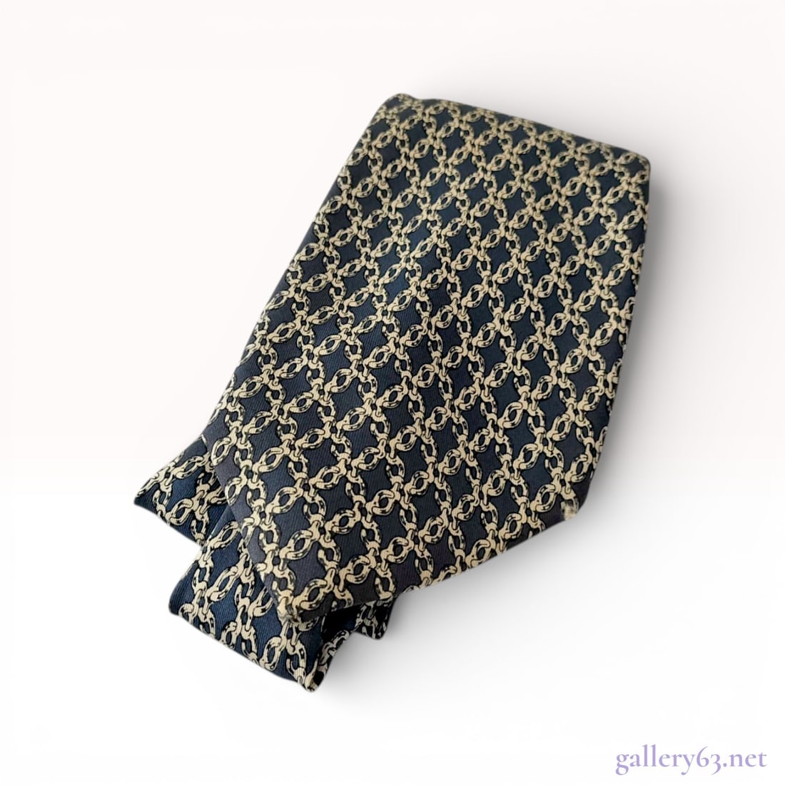 Hermes Men's Silk Necktie with Nautical Chain Link Pattern: A professional men's necktie by Hermes, expertly crafted in France from 100% silk. The accessory features an intricate, all-over interlocking nautical chain link motif in cream, contrasted against a d