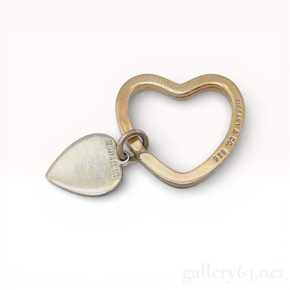Tiffany & Co. Sterling Silver Heart Keyring with Box: A classic Tiffany & Co. heart-shaped keyring crafted from .925 sterling silver. The design features a large heart-shaped split-ring mechanism designed to hold multiple keys, accented by a smaller