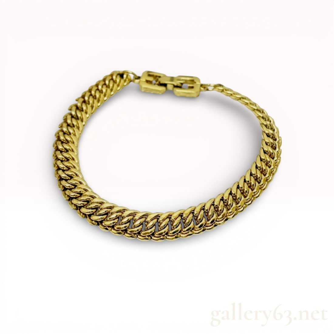 Vintage Givenchy Gold-Tone Double Curb Link Bracelet: This designer bracelet by Givenchy is crafted from polished gold-tone metal. The design features a substantial double-linked curb chain, providing a classic and chunky aesthetic. The piece is secured