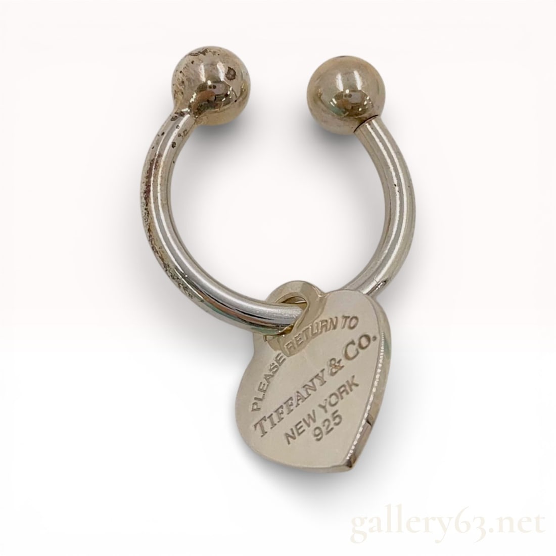 Tiffany & Co. Sterling Silver Return to Tiffany Heart Tag Horseshoe Key Ring: This sterling silver horseshoe-style key ring is a signature accessory from the iconic Return to Tiffany collection by Tiffany & Co. The design features a heavy-gauge silver horseshoe-shaped bar t