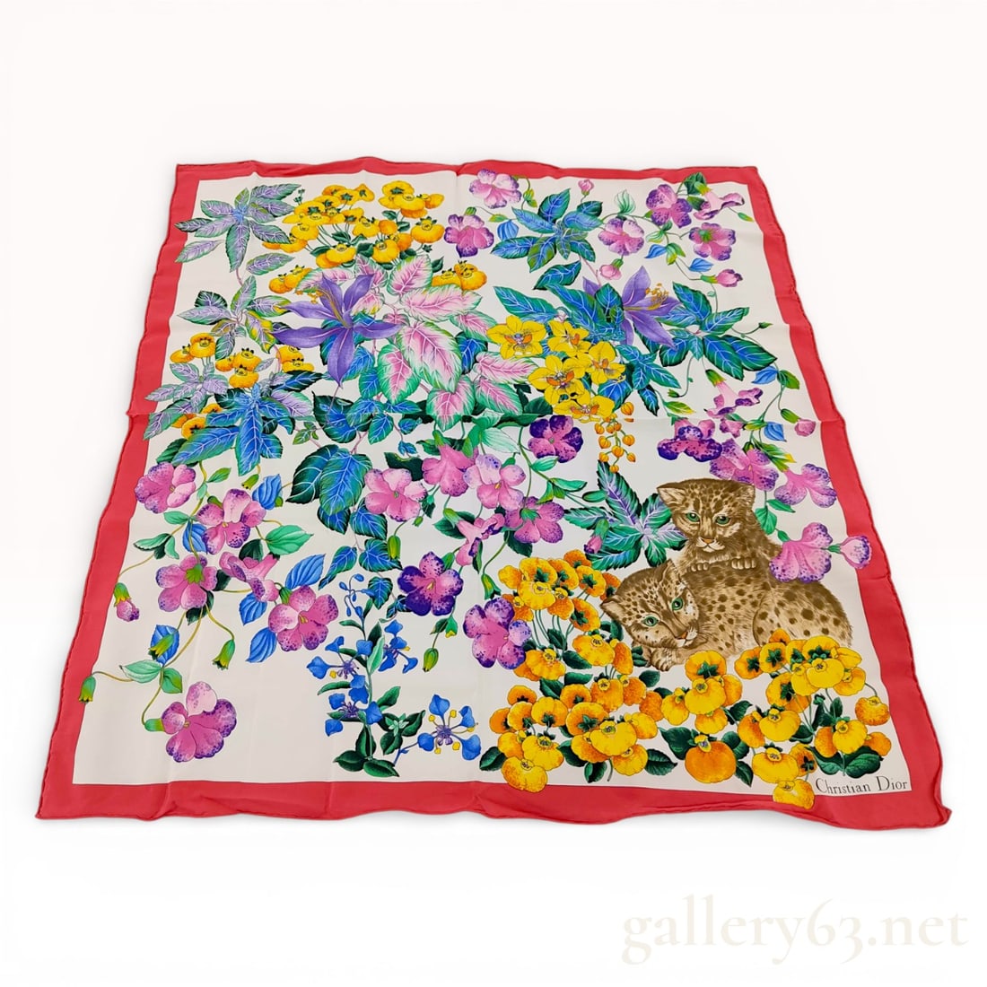 Christian Dior Silk Scarf with Floral and Leopard Cub Motif: A Christian Dior square silk scarf featuring a vibrant botanical and faunal design on a white ground. The composition includes a dense arrangement of multicolored flowers, including pansies, lilies, a