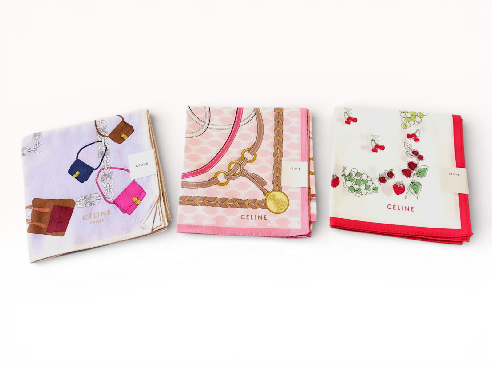 Three Céline Cotton Handkerchiefs with Equestrian, Fruit, and Handbag Motifs: This collection includes three designer handkerchiefs or pocket squares by Céline. The first piece features a light pink and white tone-on-tone Triomphe monogram field, surrounded by an equestr