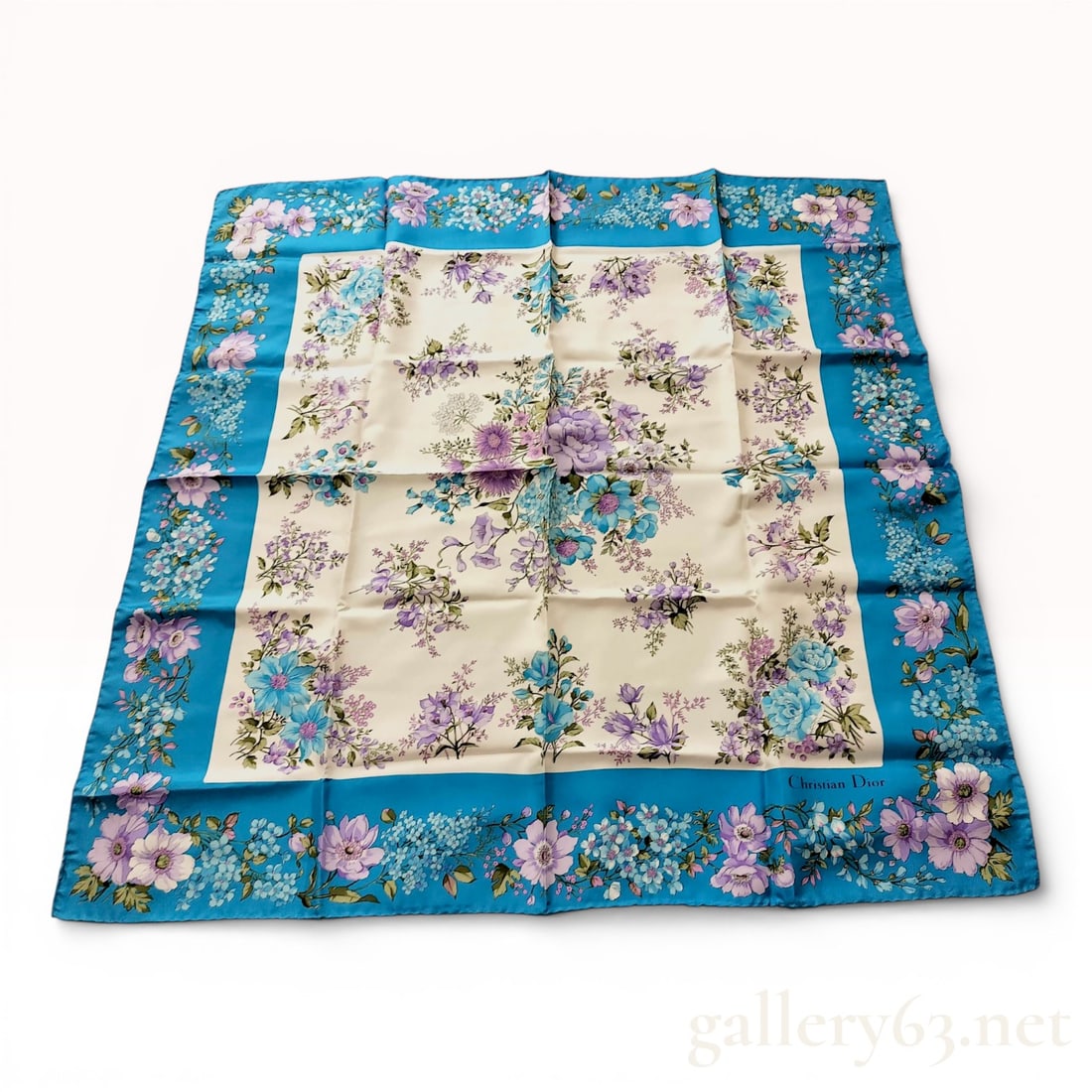 Christian Dior Vintage Silk Twill Floral Scarf: This vintage Christian Dior square scarf is crafted from 100% silk twill and features a lush floral motif in a palette of lavender, violet, and sky blue. The design centers on an off-white field fille