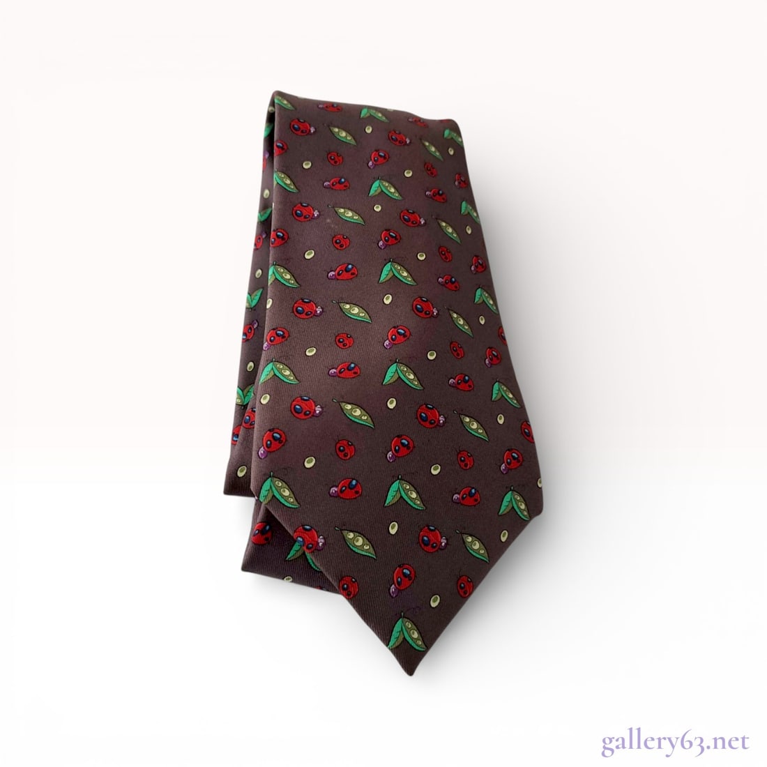 Hermes Silk Necktie, Ladybug and Pea Pod Print Silk: This Hermes necktie is crafted from 100% silk and features a whimsical repeat print of red-and-blue ladybugs, green pea pods, and small pale yellow dots. The motifs are set against a dark chocolate br