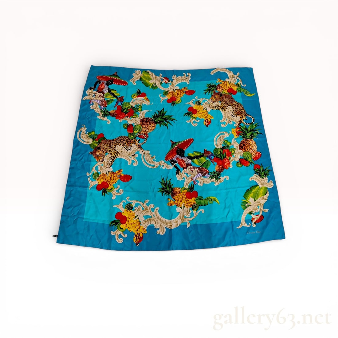 Christian Dior Silk Square Scarf Tropical Animal and Fruit Pattern: A vintage Christian Dior square silk scarf featuring a vibrant tropical motif. The design showcases exotic leopards, parrots, and pineapples amidst a variety of fruits including kiwi, berries, and ban