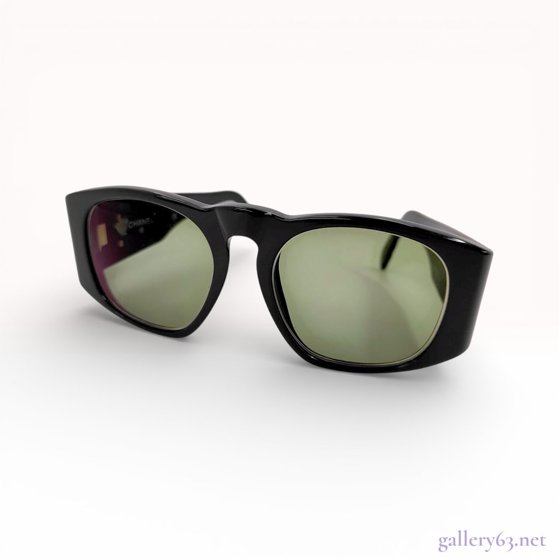 Chanel Vintage Quilted Black Acetate Sunglasses: A pair of vintage Chanel sunglasses, model 01450 94305. These women's sunglasses are crafted with black acetate frames and feature green-tinted lenses. The temples showcase the iconic Chanel diamond-q