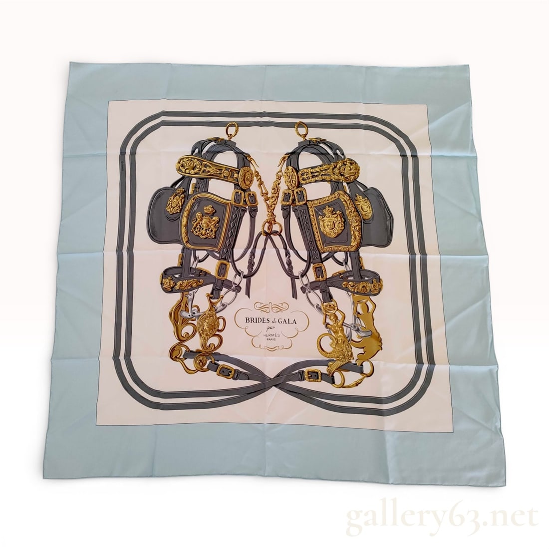 Hermes Silk Twill Scarf in Brides de Gala Pattern: This classic Hermes Carre 90 silk twill scarf features the iconic Brides de Gala design. The pattern depicts two ceremonial horse bridles with intricate gold-toned hardware and crests, symmetrically a