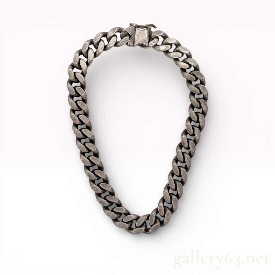 Sterling Silver Heavy Curb Link Bracelet with Oxidized Finish: A heavy sterling silver bracelet in a curb link style featuring thick, rounded links. The piece is characterized by a deep oxidized patina throughout. It is fitted with an integrated box clasp and a s