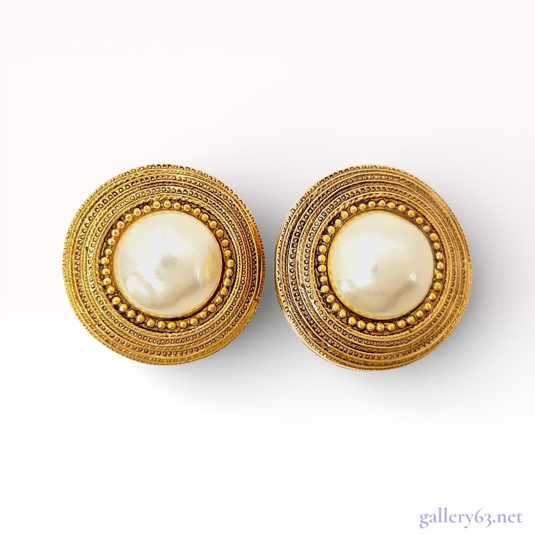Gold-Tone Clip-On Earrings with Faux Mabe Pearl Centers, Chanel c. 1980s: A matched pair of vintage gold-tone base metal clip-on earrings in a large button style. Each earring features a central cream-colored faux mabe pearl cabochon bezel-set within a multi-tiered circular