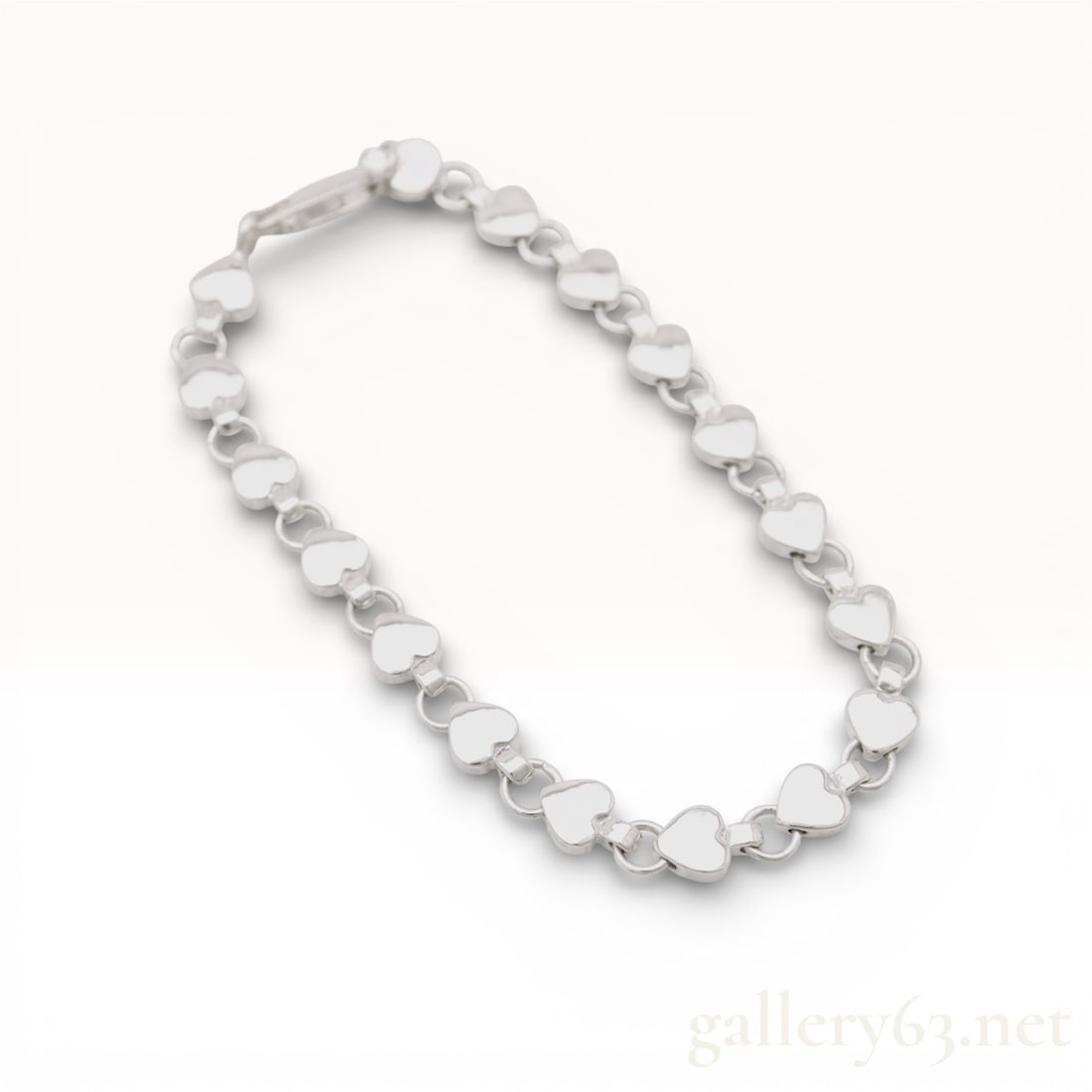 Sterling Silver Tiffany & Co. Puffed Heart Link Bracelet: A sterling silver link bracelet by Tiffany & Co. featuring a continuous series of polished, puffed heart-shaped links. Each heart link is connected by a single round jump ring, creating a flexible