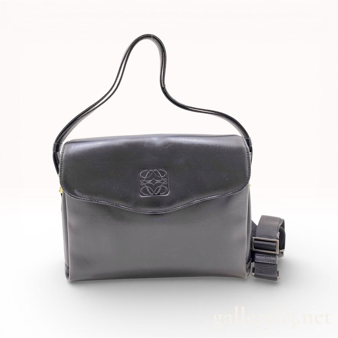Loewe Vintage Anagram Flap Shoulder Bag Black Calfskin Leather: This vintage Loewe shoulder bag is crafted from smooth black calfskin leather and features a classic rectangular silhouette with a front flap closure. The flap is prominently detailed with a large, ce