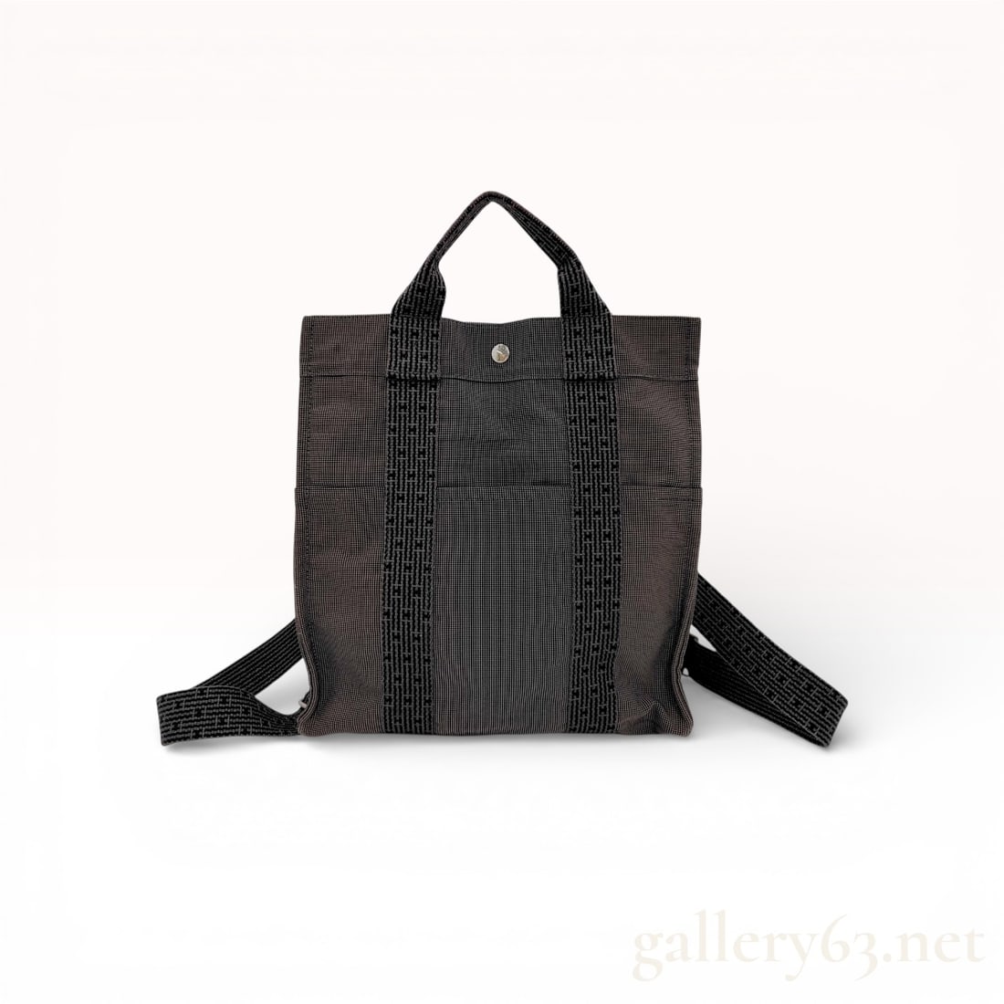 Hermes Herline MM Backpack in Grey Woven Canvas: This Hermes Herline MM backpack is crafted from a durable grey and black woven polyamide and polyester canvas. The exterior features two vertical black canvas bands woven with the signature "H&qu
