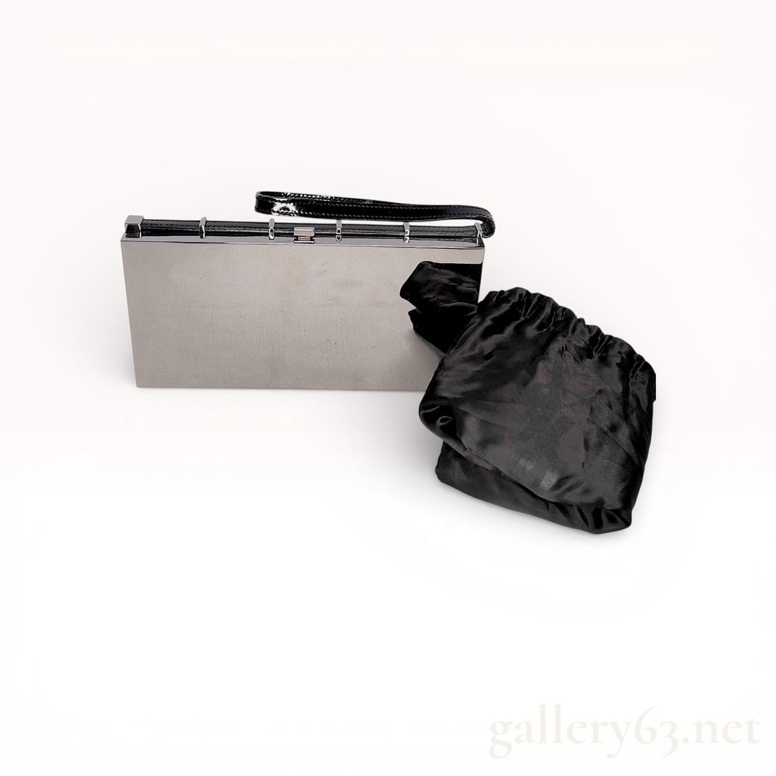 Yves Saint Laurent Mirror-Finish Hard Case Evening Clutch, Silver and Black Patent Leather: This vintage Yves Saint Laurent minaudière features a minimalist architectural design with a highly polished silver-tone metal hard-case shell. The top frame is accented with black patent leath