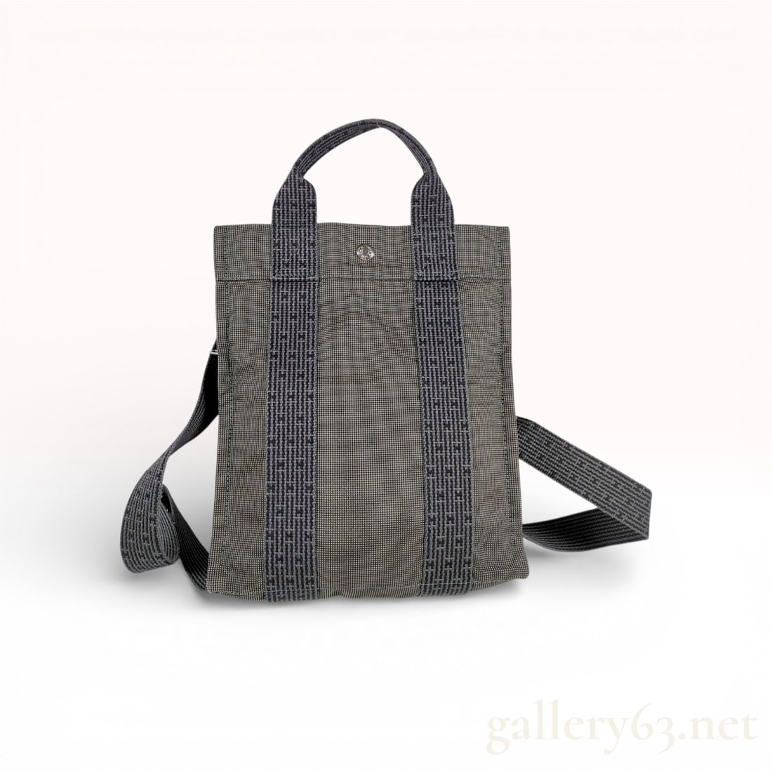 Hermes Herline Ado PM Canvas Backpack, Grey: An authentic Hermes Herline Ado backpack, size PM, crafted from durable woven technical canvas in a versatile grey and charcoal palette. This minimalist design features the signature "H" log