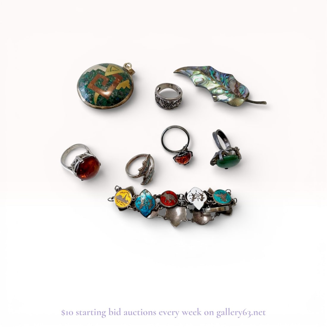 Sterling Silver Jewelry Collection Featuring Mexican Inlay and Enamel: A diverse collection of vintage jewelry pieces crafted from sterling silver. The lot features a prominent Mexican Married Metals circular pendant with a crushed malachite mosaic background and geometr