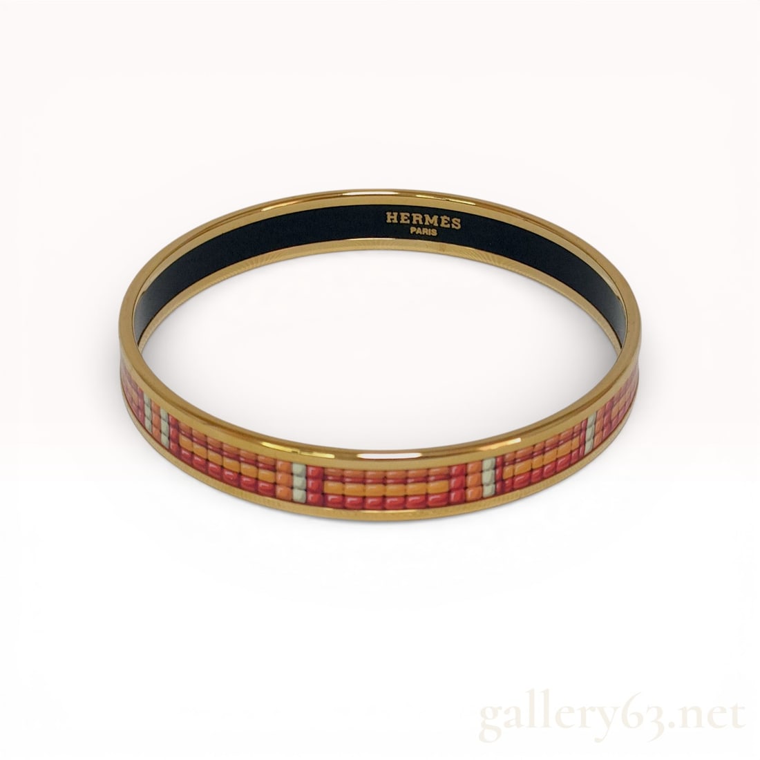 Gold-Plated Enamel Bangle Bracelet, Hermes Astrologie Nouvelle Pattern with Box: This narrow rigid bangle by Hermes is crafted from gold-plated metal featuring a vibrant enamel inlay. The exterior design displays a multicolored geometric grid motif in a palette of orange, brick re