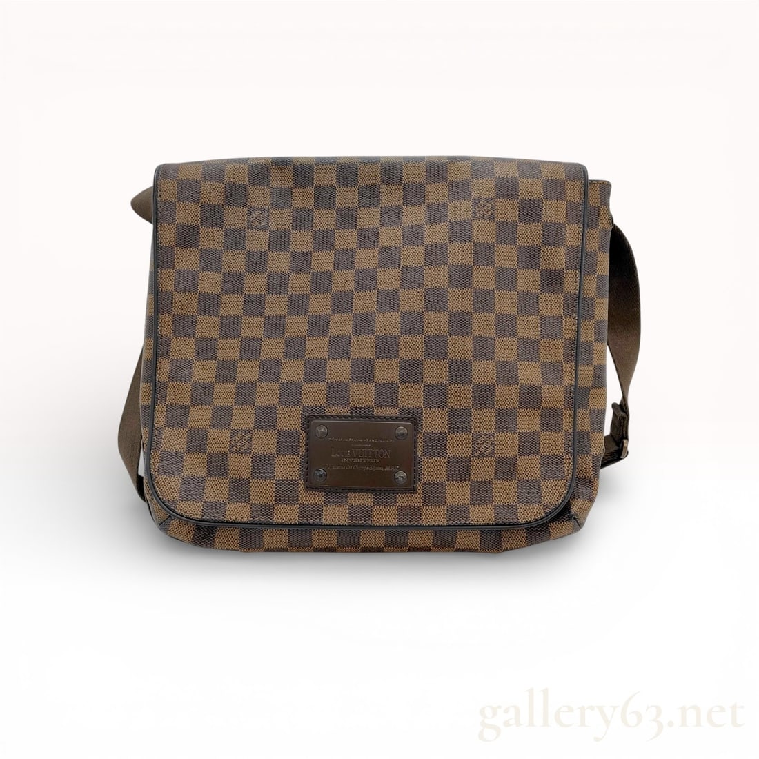 Louis Vuitton Brooklyn MM Messenger Bag Damier Ebene Brown: This Louis Vuitton Brooklyn MM messenger bag is crafted from the signature Damier Ebene coated canvas with dark brown leather trim. The design features a large front flap with a concealed magnetic