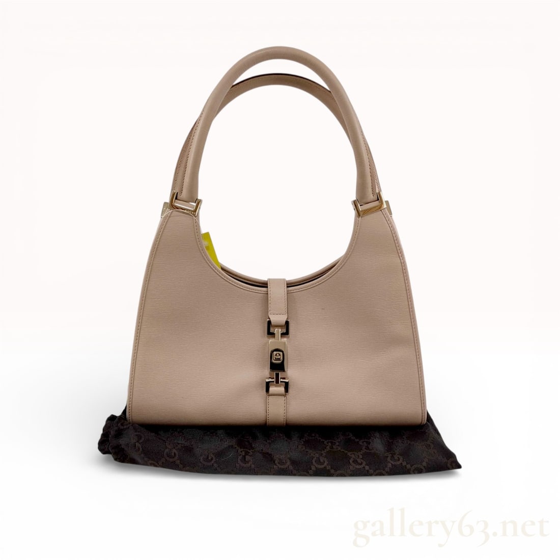 Gucci Jackie Piston Hobo Bag in Beige Textured Leather: A Gucci Jackie hobo bag crafted from beige textured calfskin leather with tonal stitching. This iconic silhouette features dual rolled leather handles and a signature silver-tone piston-lock closure